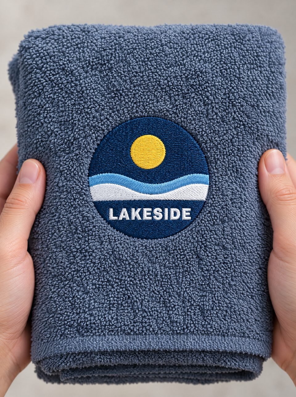 Lakeside Swim Club, gestickt auf dem Textil, in zwei Händen gehalten
